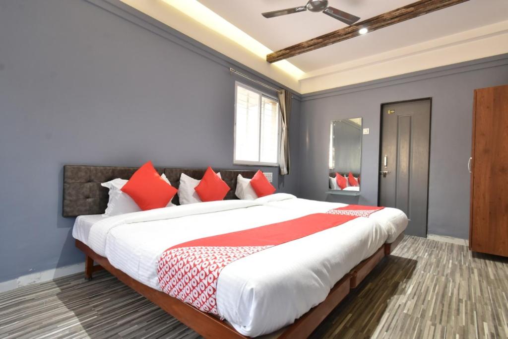 a bedroom with a large bed with red pillows at Hotel Ashirwad, Solapur in Solapur