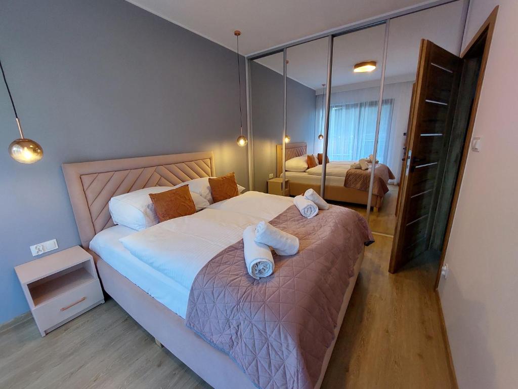 een slaapkamer met een bed met twee handdoeken erop bij Apartament Trójkąty i Kwadraty Karpatia Resort in Karpacz