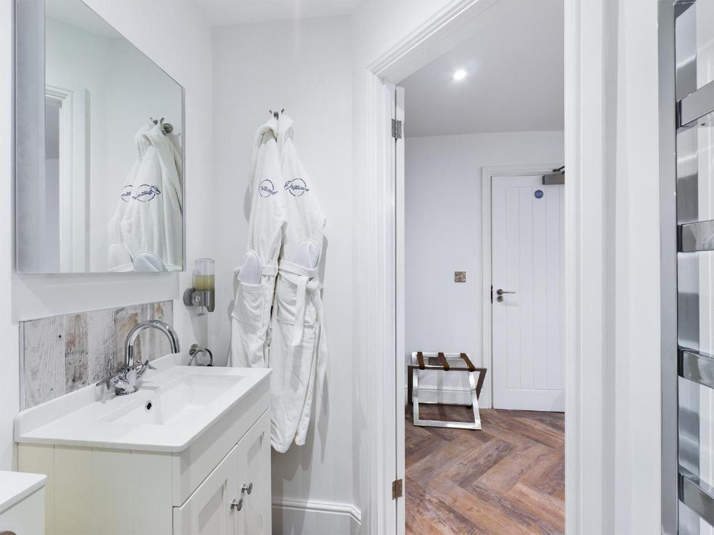 a white bathroom with a sink and a mirror at Driftwood Boutique Guest House in Rhosneigr