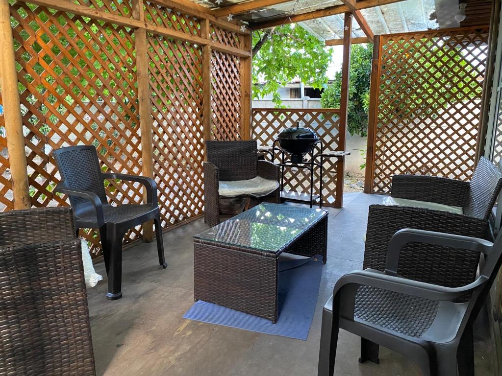 a patio with chairs and a table and a grill at Cabaña en Quinchamalí in Quinchamali