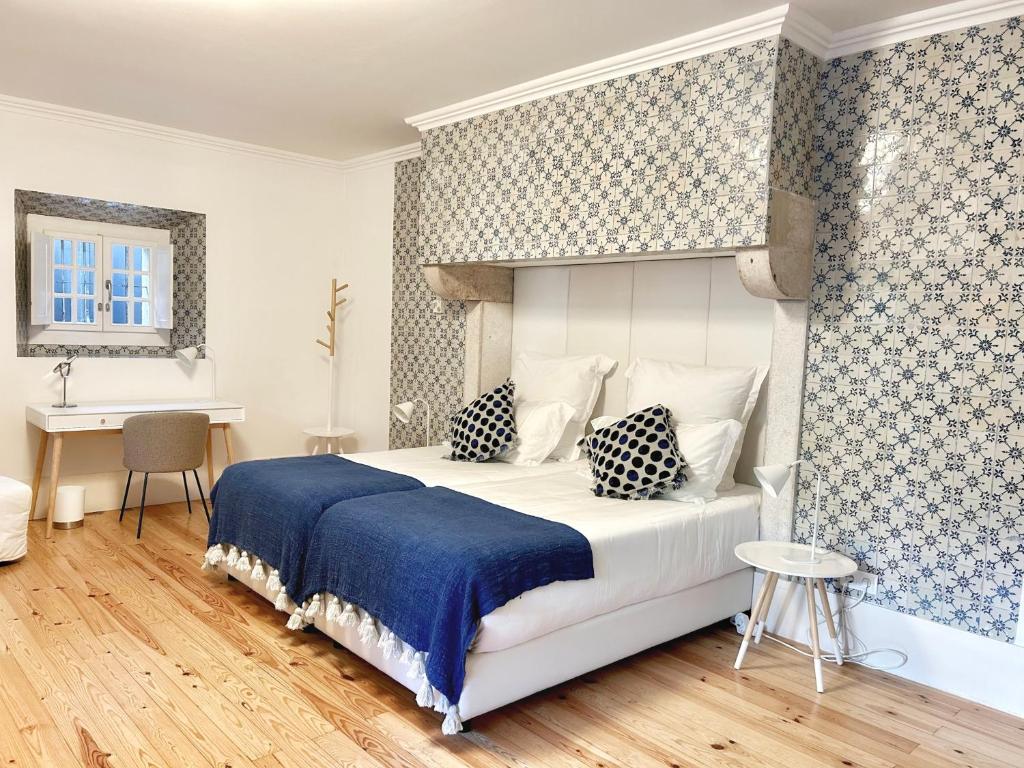 a bedroom with a large bed and a desk at Villa Vasco da Gama in Cascais
