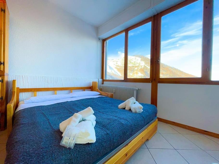 a bedroom with a blue bed with towels on it at 150m DALLE PISTE - Parcheggio Gratis in Sella della Turra