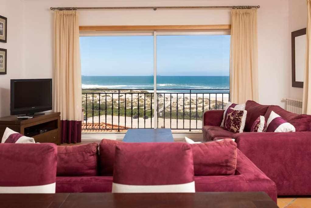 ein Wohnzimmer mit einem roten Sofa und einem großen Fenster in der Unterkunft T2 Praia Del Rey Fantástica Vista Mar Óbidos A4 in Casal da Lagoa Seca