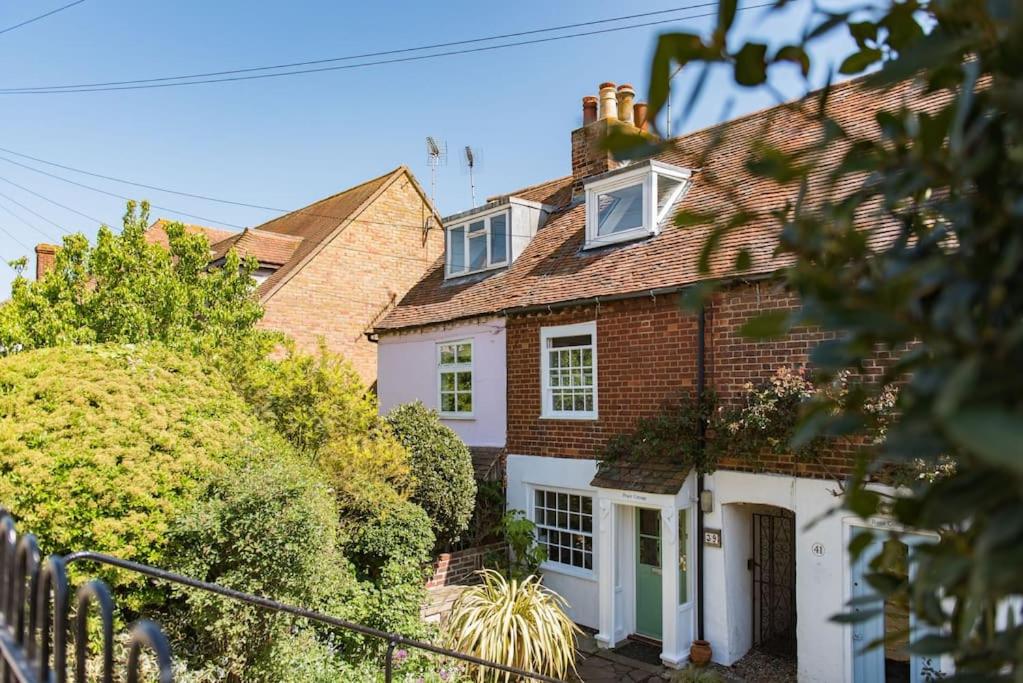 a red brick house with a white garage at Peace Cottage in Whitstable