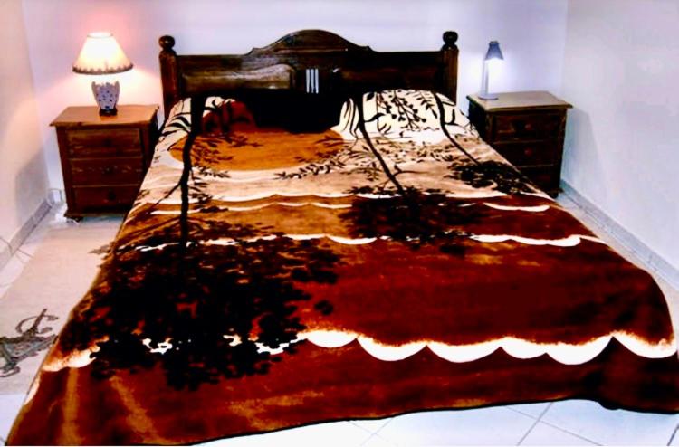 a large bed in a bedroom with two night stands at Appartment Jamila a Agadir in Agadir