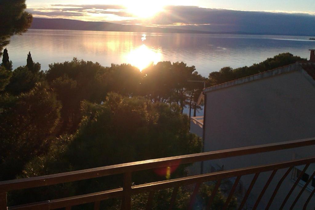 a view of the sun setting over the water at Summerhouse Duće Omiš in Duće