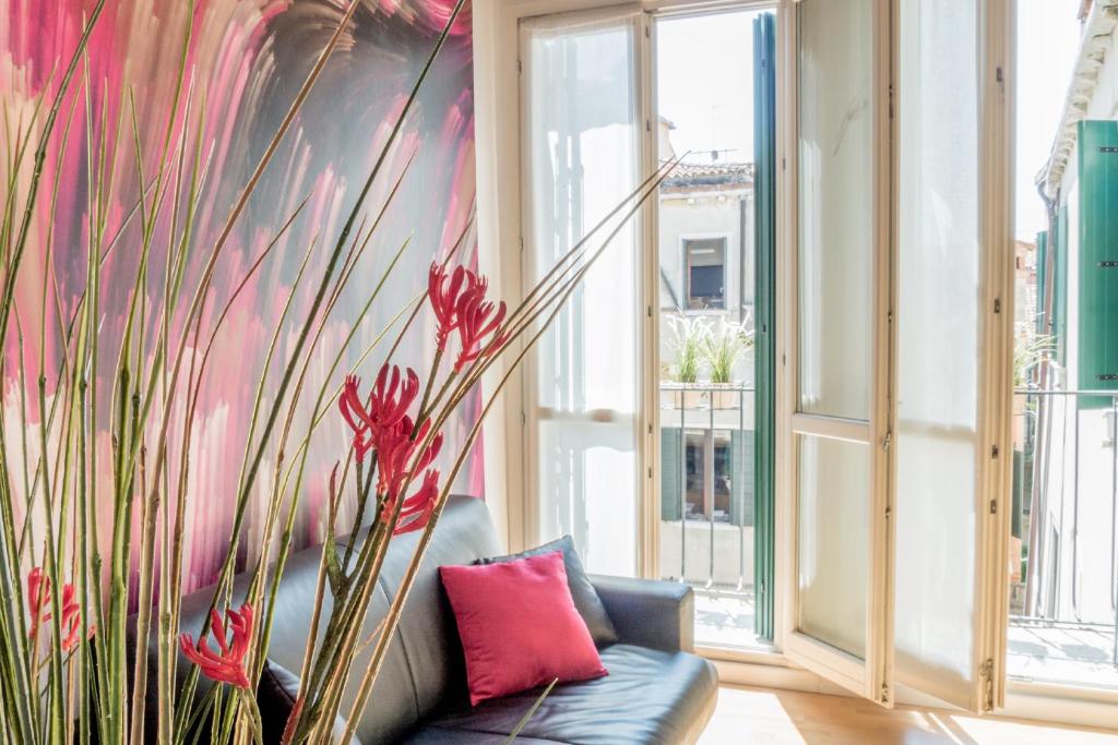 een bank in een kamer met een muur van ramen bij San Polo Design Apartments by Wonderful Italy in Venetië