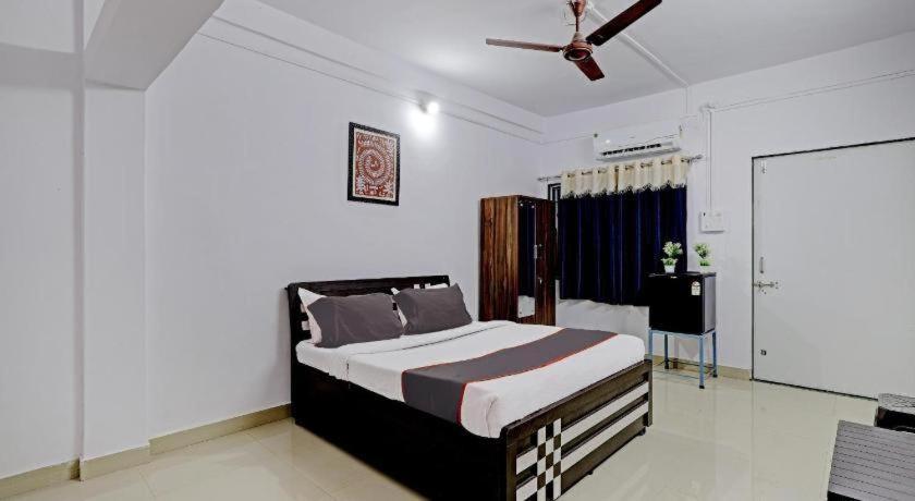 a bedroom with a bed and a ceiling fan at Vrundavan home stay and Village resort in Kevadia