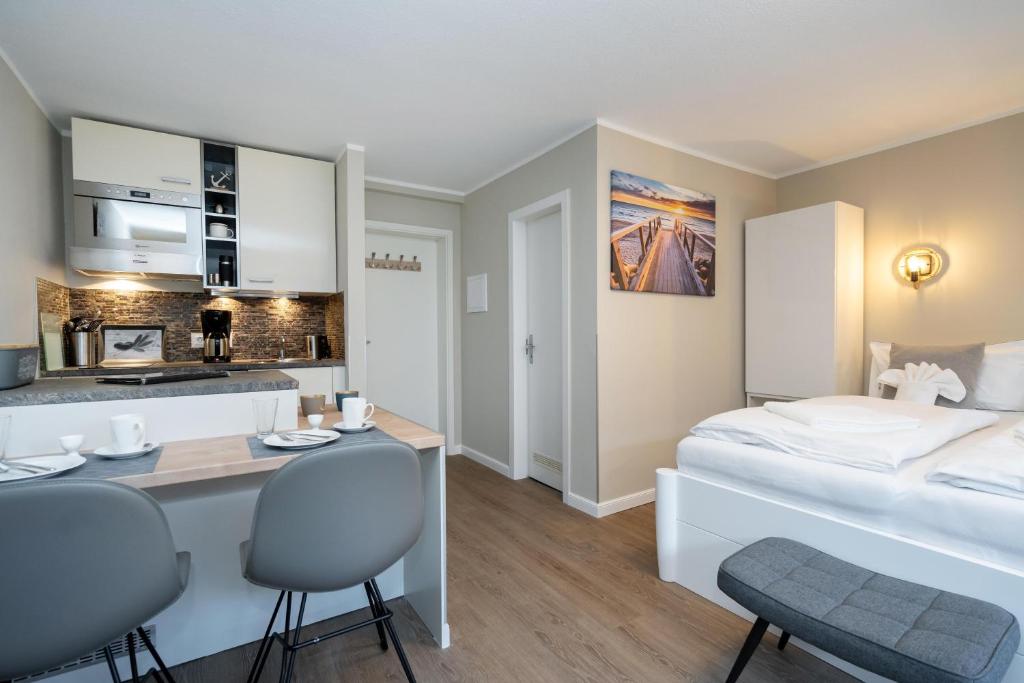 1 Schlafzimmer mit einem Bett, einer Küche und einem Schreibtisch in der Unterkunft Sylter Rose in Westerland