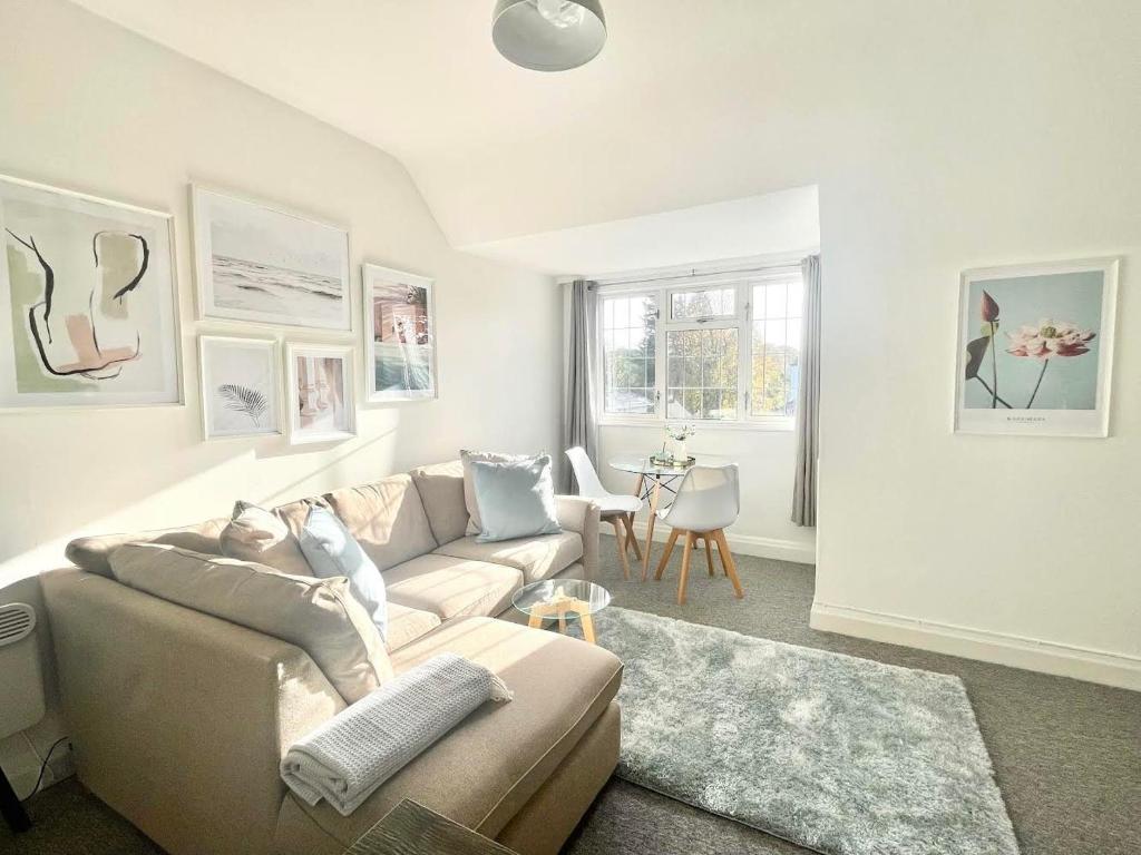ein Wohnzimmer mit einem Sofa und einem Tisch in der Unterkunft Four Oaks in Bournemouth