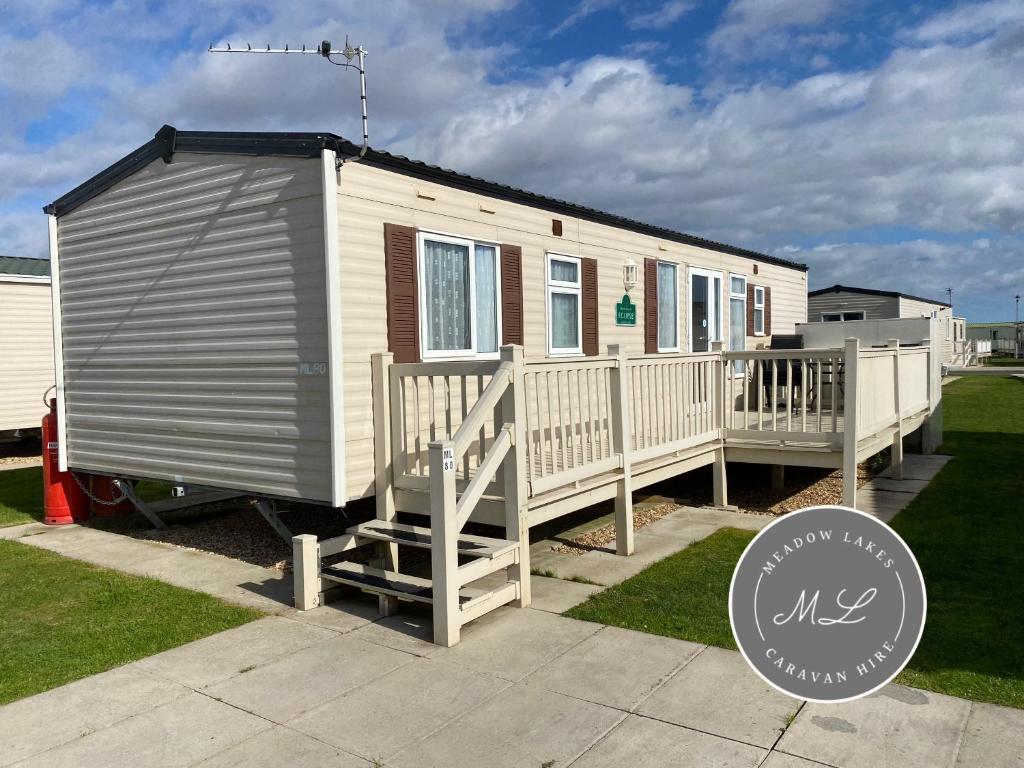 a tiny house with a porch and a deck at Golden Palm Resort - Meadow Lakes 80 - ML80 in Chapel Saint Leonards