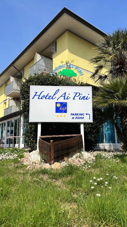 un hôtel signe plus devant un bâtiment dans l'établissement Hotel Ai Pini, à Grado