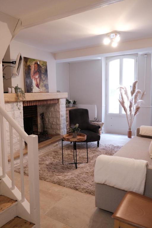 ein Wohnzimmer mit einem Kamin und einem Sofa in der Unterkunft Gîte le petit écolier in Lectoure