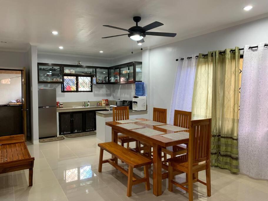 a dining room with a table and chairs and a kitchen at Entire Island home with Starlink and gated parking in Dapa