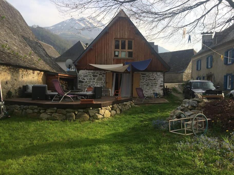 una casa con mesa y sillas en un patio en La Grange d'Emmanuel, Marsous, 6-8 pers en Arrens-Marsous