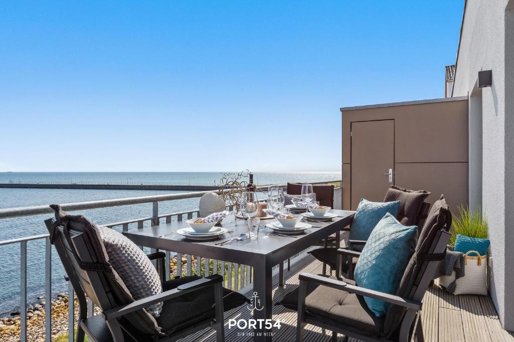 - Mesa de comedor en el balcón con vistas al océano en Seewind, en Olpenitz