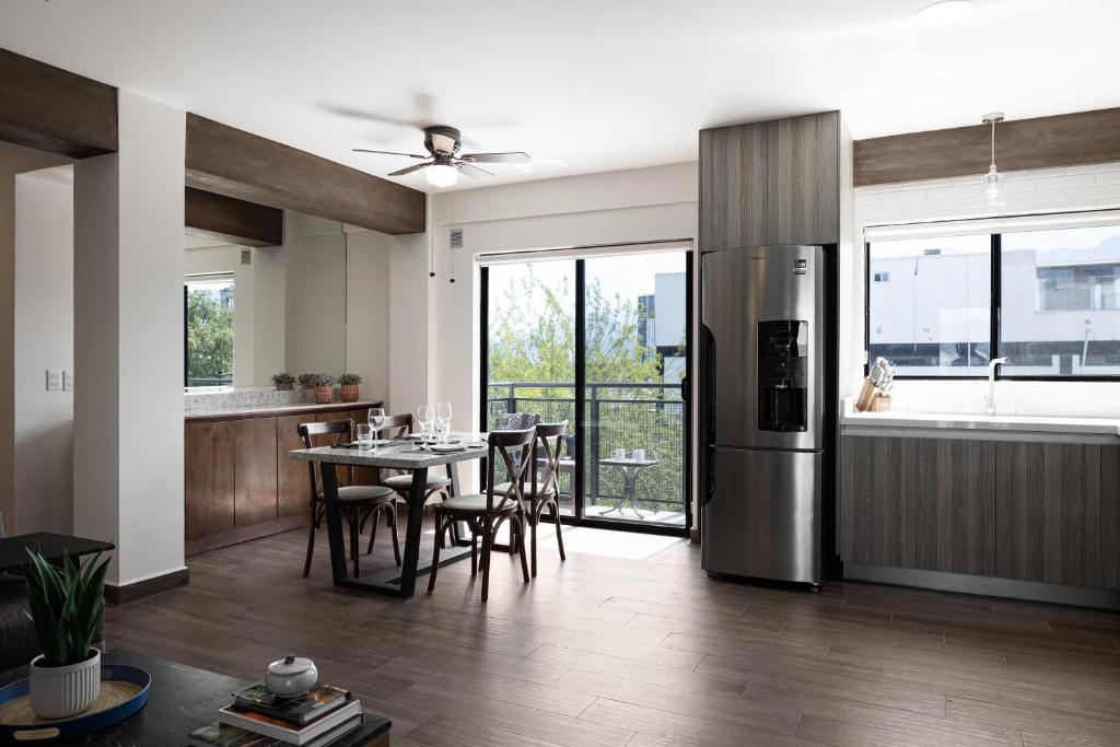 a kitchen and dining room with a stainless steel refrigerator at Vista al Cerro de La Silla, nuevo con amenidades en Tulancingo 9 in Monterrey