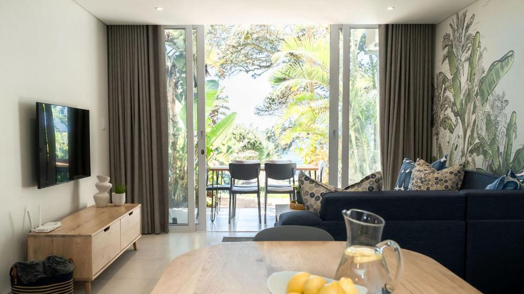 a living room with a couch and a table at Newly renovated stylish Mallorca Apartment in Umdloti