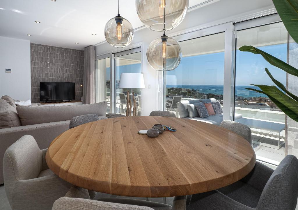 ein Esszimmer mit einem Holztisch im Wohnzimmer in der Unterkunft Magnificent penthouse with panoramics views in Casares