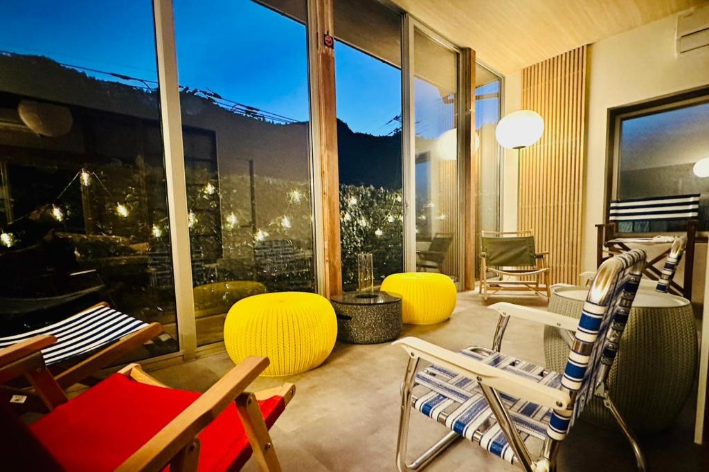 青梅市的住宿－加美屋リゾート奥多摩 テラス＆風呂，客厅配有椅子和大窗户