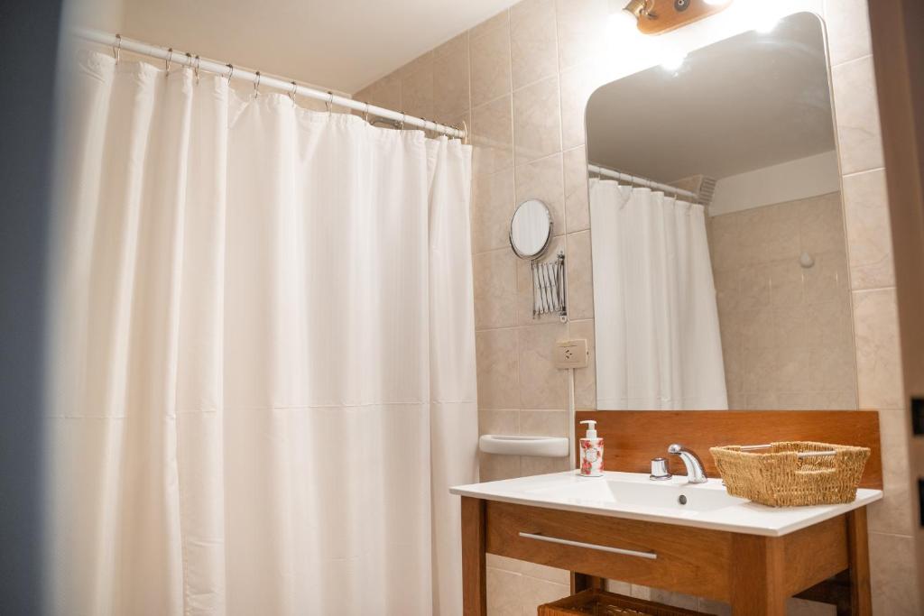 ein Badezimmer mit einem weißen Duschvorhang und einem Waschbecken in der Unterkunft Departamento Las 3 Marías in San Carlos de Bariloche