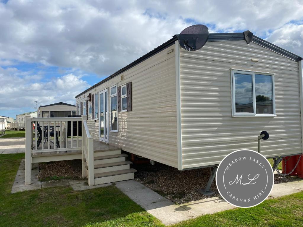 a white tiny house with a porch and stairs at Golden Palm Resort - Meadow Lakes 72 - ML72 in Chapel Saint Leonards