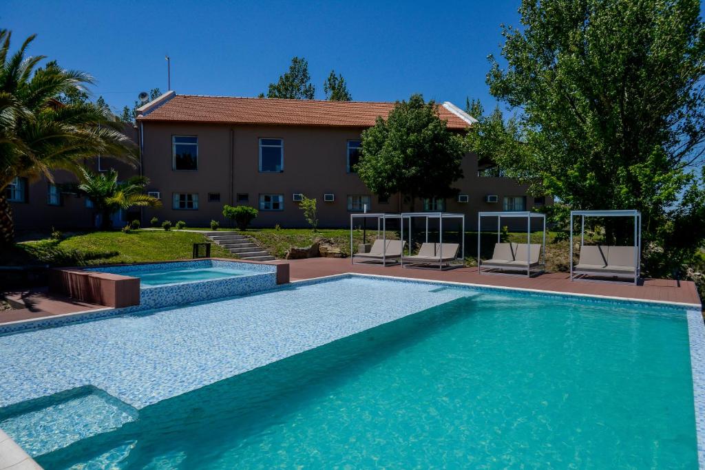 uma piscina em frente a uma casa em Hotel La Huertita em Libertador General San Martín