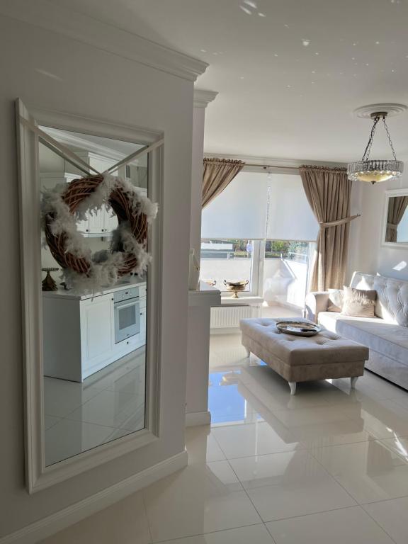 ein Wohnzimmer mit einem Spiegel und einem Sofa in der Unterkunft Apartament Parys Gold in Malbork