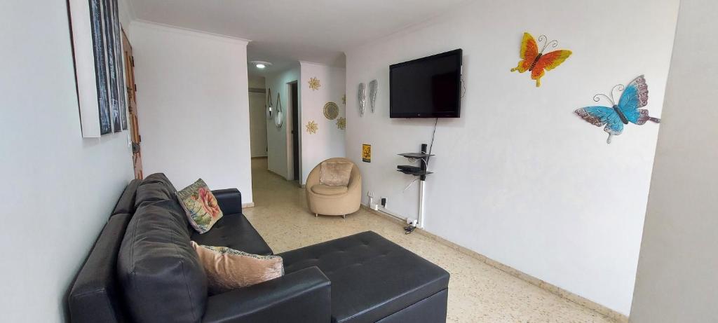 a living room with a couch and a tv on a wall at Apartamento Sector Colores - Estadio in Medellín