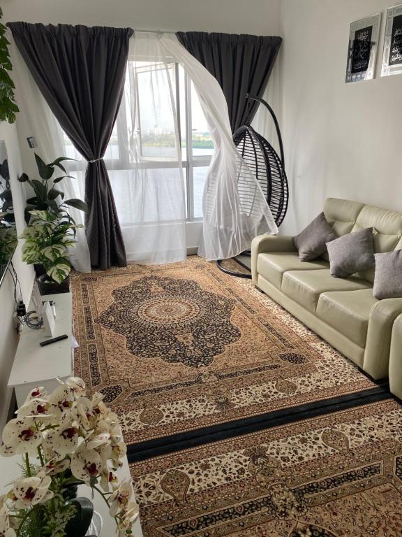 uma sala de estar com um sofá e um tapete em SKF Homestay em Puchong