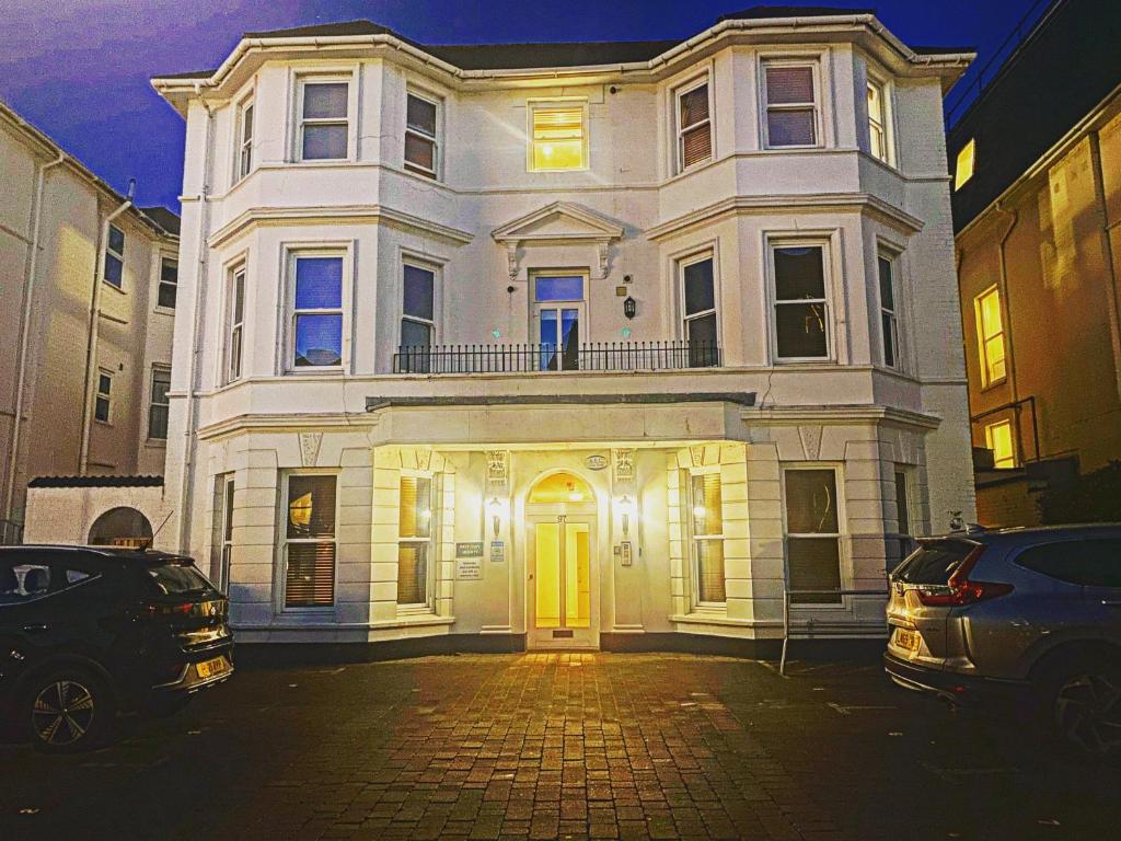 una casa blanca con una puerta amarilla en una calle en LUXURY 2 BEDS APARTMENT BY THE SEA, en Bournemouth