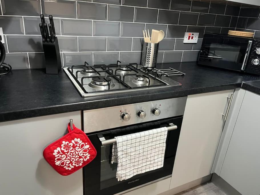 a kitchen with a stove with a red bag on it at Woolfall House in Roby