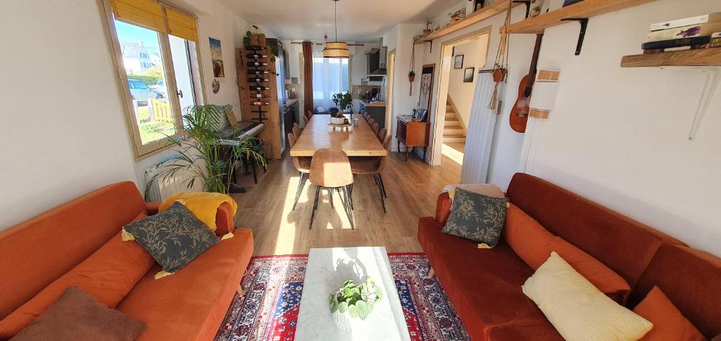 sala de estar con sofás naranjas y mesa en Surfhouse, L'Oyat, en Saint-Pierre-Quiberon
