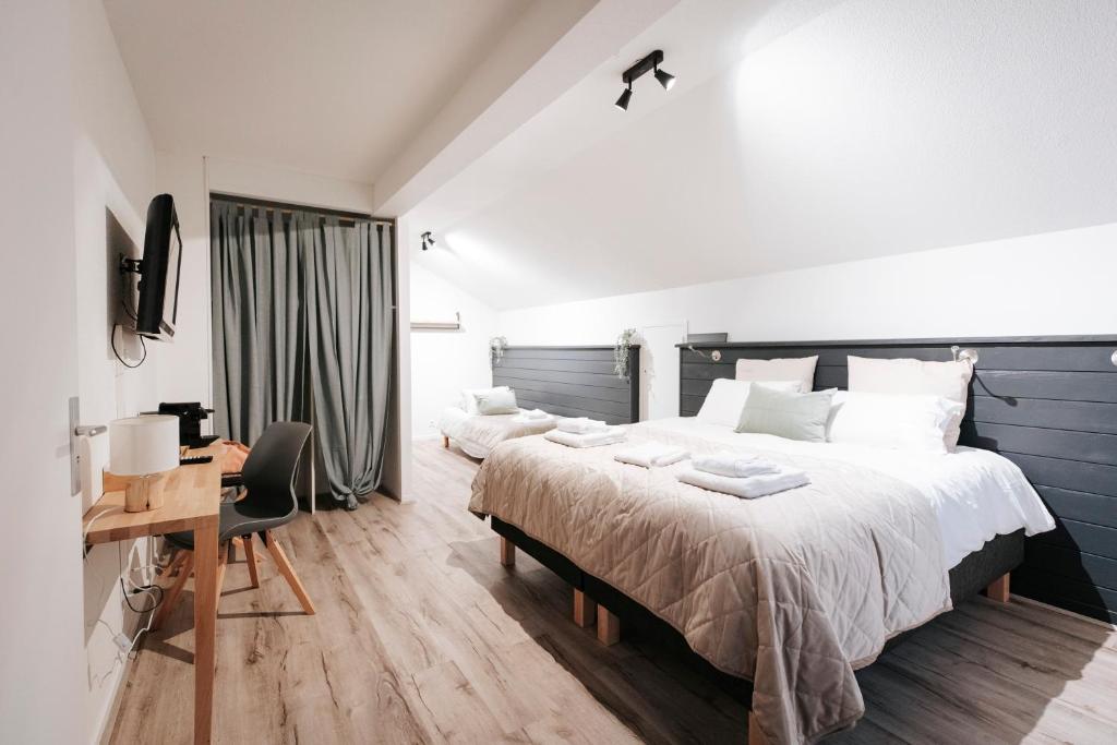 een slaapkamer met een groot bed en een bureau bij Les Loges du Léman in Crozet
