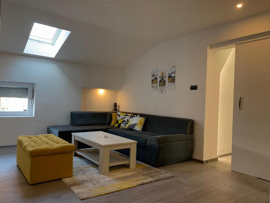 een woonkamer met een bank en een tafel bij Apartment Grey in Sarajevo