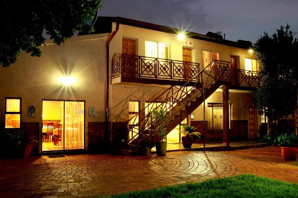 a house with a staircase in front of it at night at Clubview Guest House in Centurion