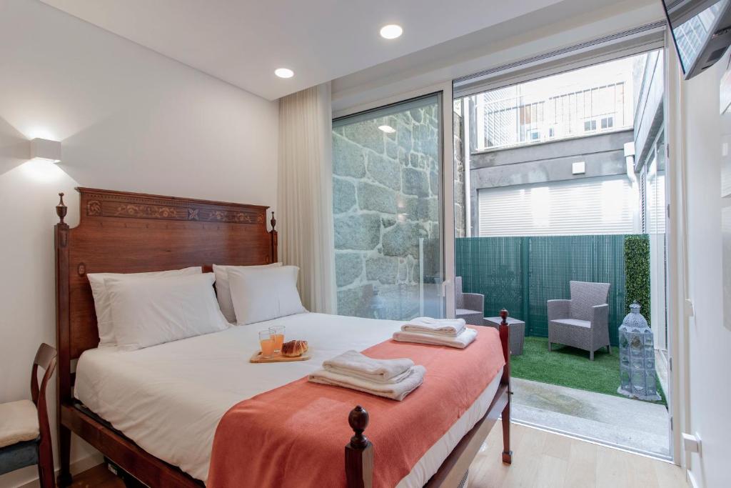 ein Schlafzimmer mit einem Bett mit zwei Handtüchern darauf in der Unterkunft Cozy Studio w/ Patio by LovelyStay in Porto