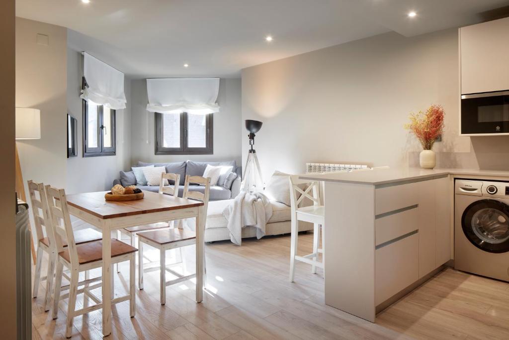 eine Küche und ein Wohnzimmer mit Tisch und Stühlen in der Unterkunft Tanau by FeelFree Rentals in Naut Aran