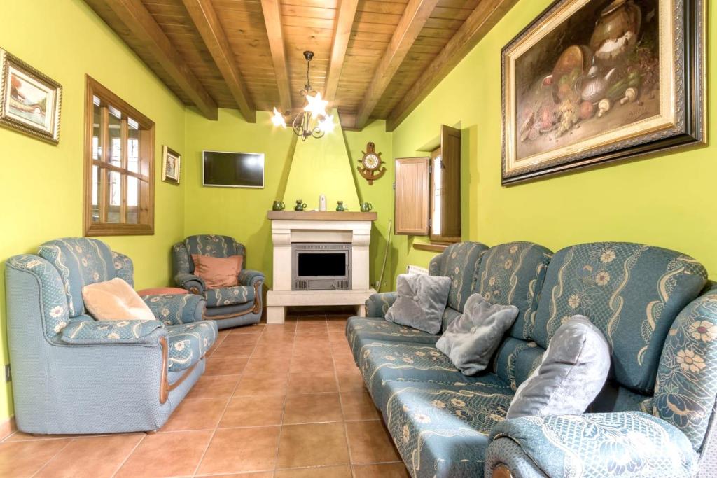 ein Wohnzimmer mit blauen Sofas und einem Kamin in der Unterkunft 3 bedrooms house with city view enclosed garden and wifi at Trescares in Trescares