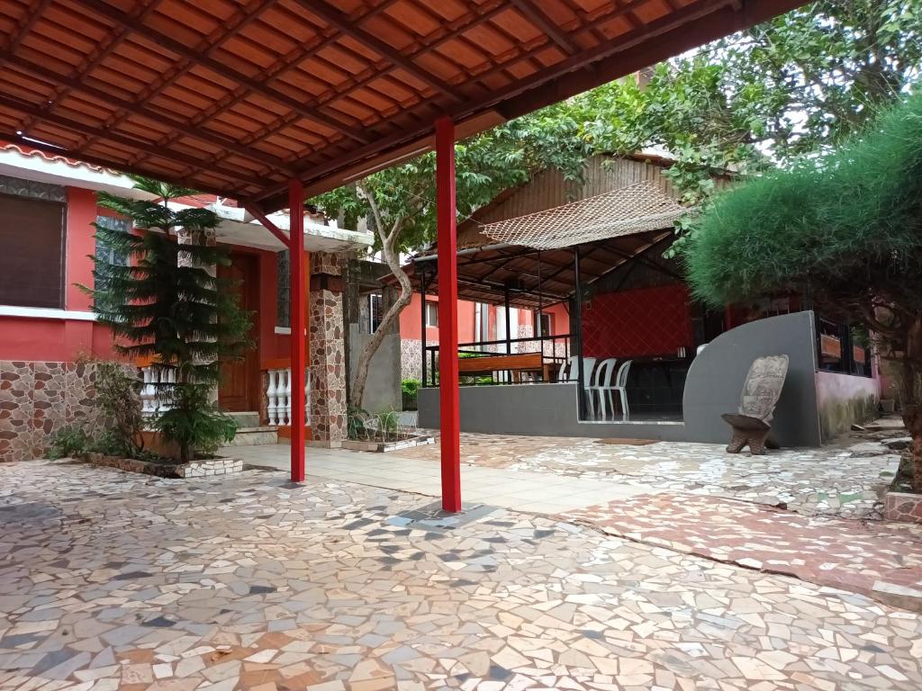 un pavillon avec une terrasse en pierre en face d'un bâtiment dans l'établissement HOTEL BADINCA Alojamento Low Cost in Bissau avenida FRANCISCO MENDES, à Bissau