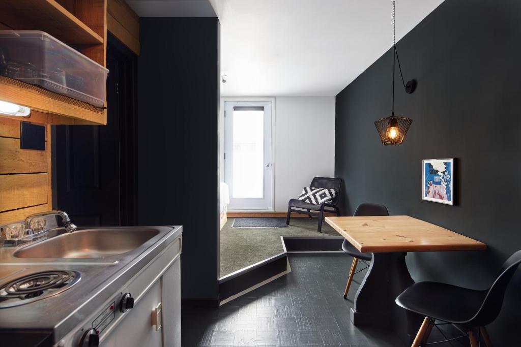 eine Küche mit einem Waschbecken und einem Holztisch in der Unterkunft Beatnik Hotel in Bromont