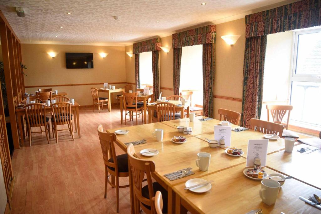 uma grande sala de jantar com mesas e cadeiras em The Caledonian em Portree