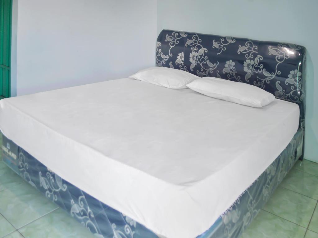 Łóżko lub łóżka w pokoju w obiekcie OYO 1745 Guest House Nur Aziziah Syariah 2