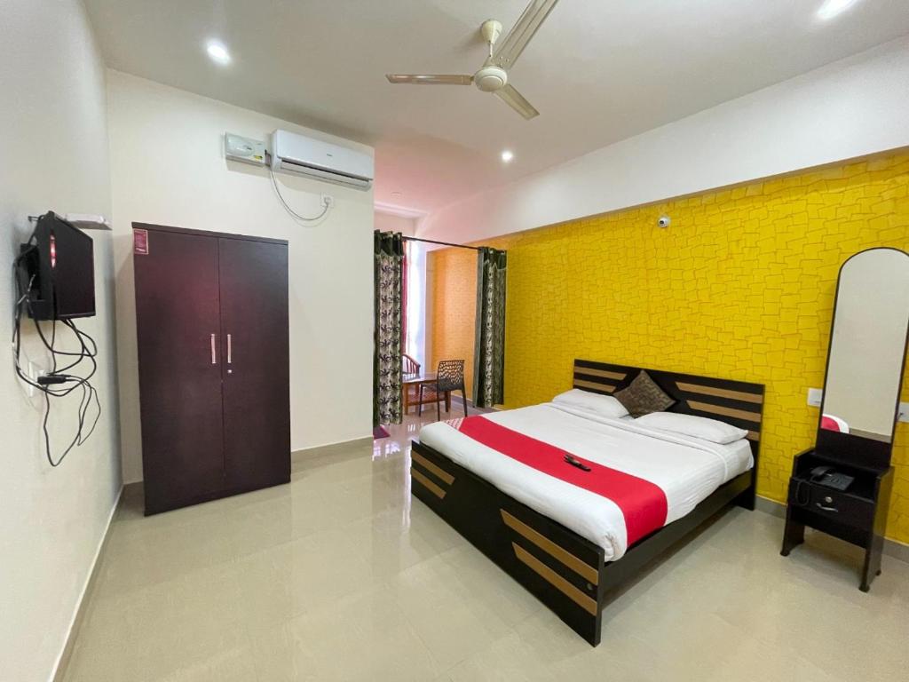 a bedroom with a bed and a yellow wall at Green Valley Residency in Gundlupet