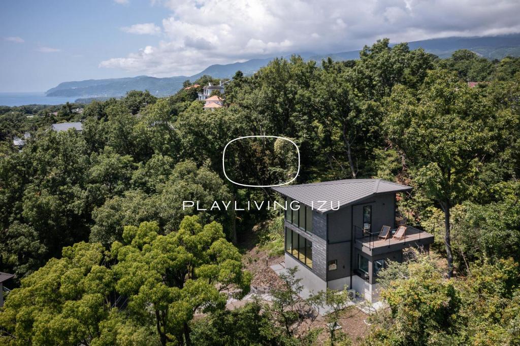 uma vista aérea de uma casa na floresta em Playliving IZU - A ocean view villa with Onsen em Ito