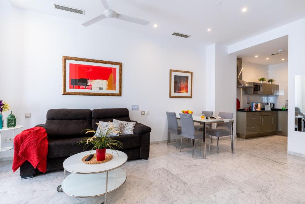 salon z kanapą i stołem w obiekcie Sevilla Central Suites Apartamentos Puerta Jerez w Sewilli