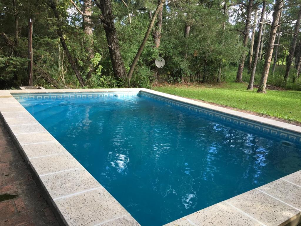 una piscina azul en un patio con árboles en La Providencia Eco Casa en Corrientes