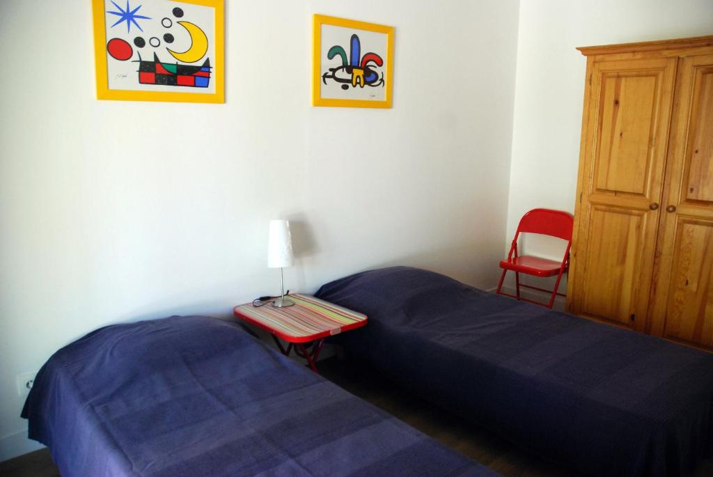 sypialnia z niebieskim łóżkiem i czerwonym krzesłem w obiekcie Le Mas de la Palmeraie - Appartement dans propriété privée au calme avec piscine et tennis w mieście Bormes-les-Mimosas