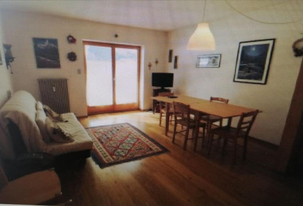 a living room with a table and chairs and a dining room at La casa di Antonello Chiara Alessandro e Ginevra in Malga Ciapela