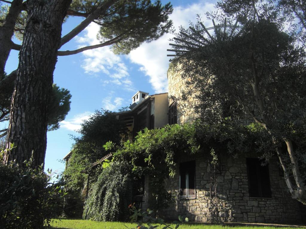 パッシニャーノ・スル・トラジメーノにあるELIO e DONYの手前に木が植えられた古い石造りの建物